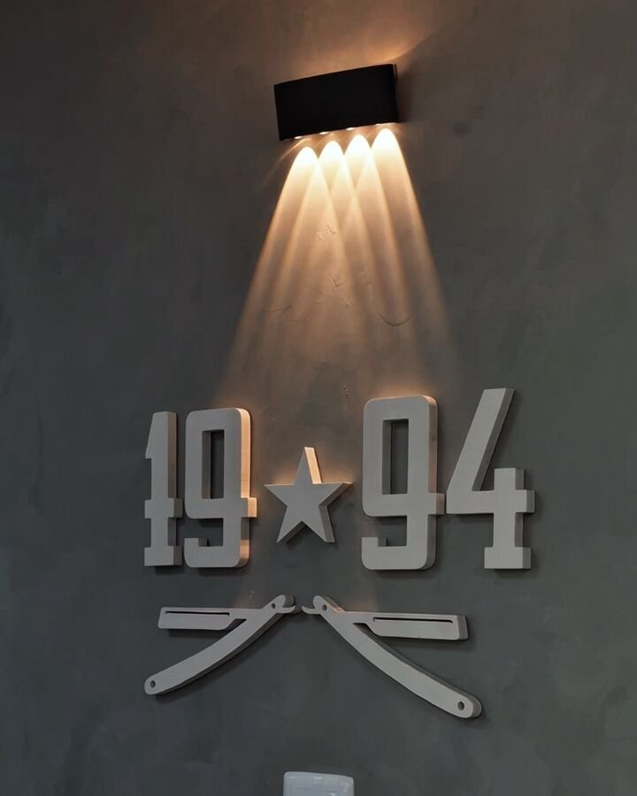 Letreiro 1994 iluminado na parede da barbearia